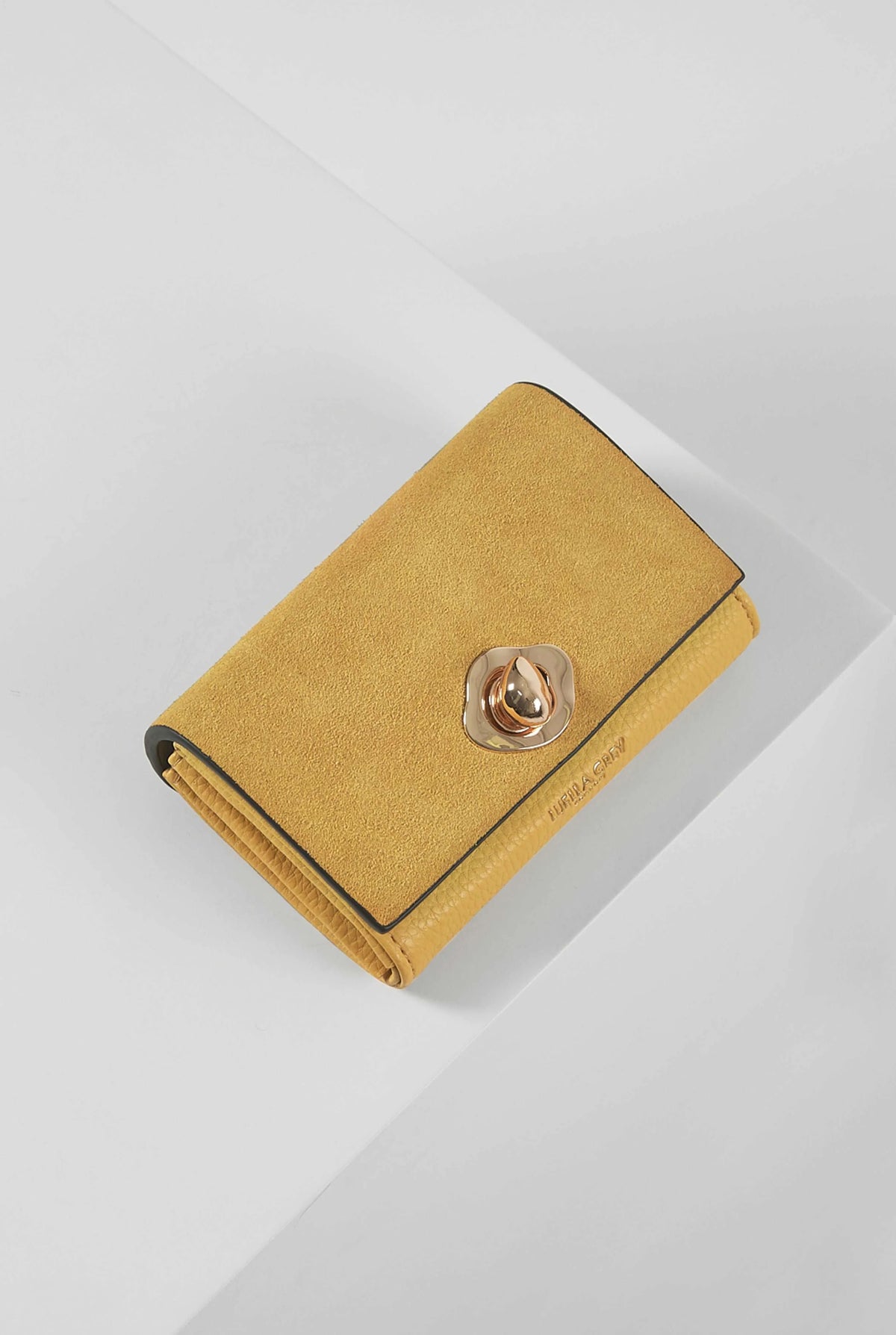 Yellow suede wallet with round metal snap and fold-over flap