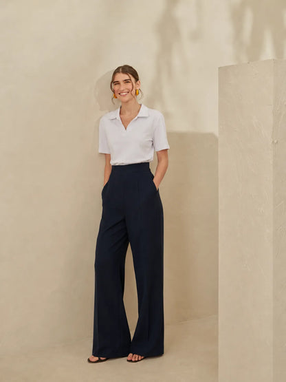 Women's white short-sleeve blouse with pointed collar; dark wide-leg trousers