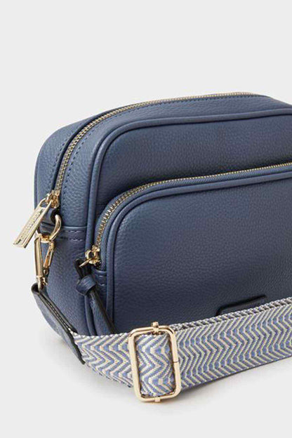 Blue crossbody bag with chevron lining, front zip pocket, gold hardware