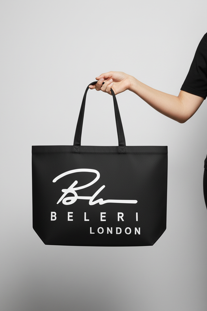 Jet black tote bag with Beleri London logo, top handles; held by hand
