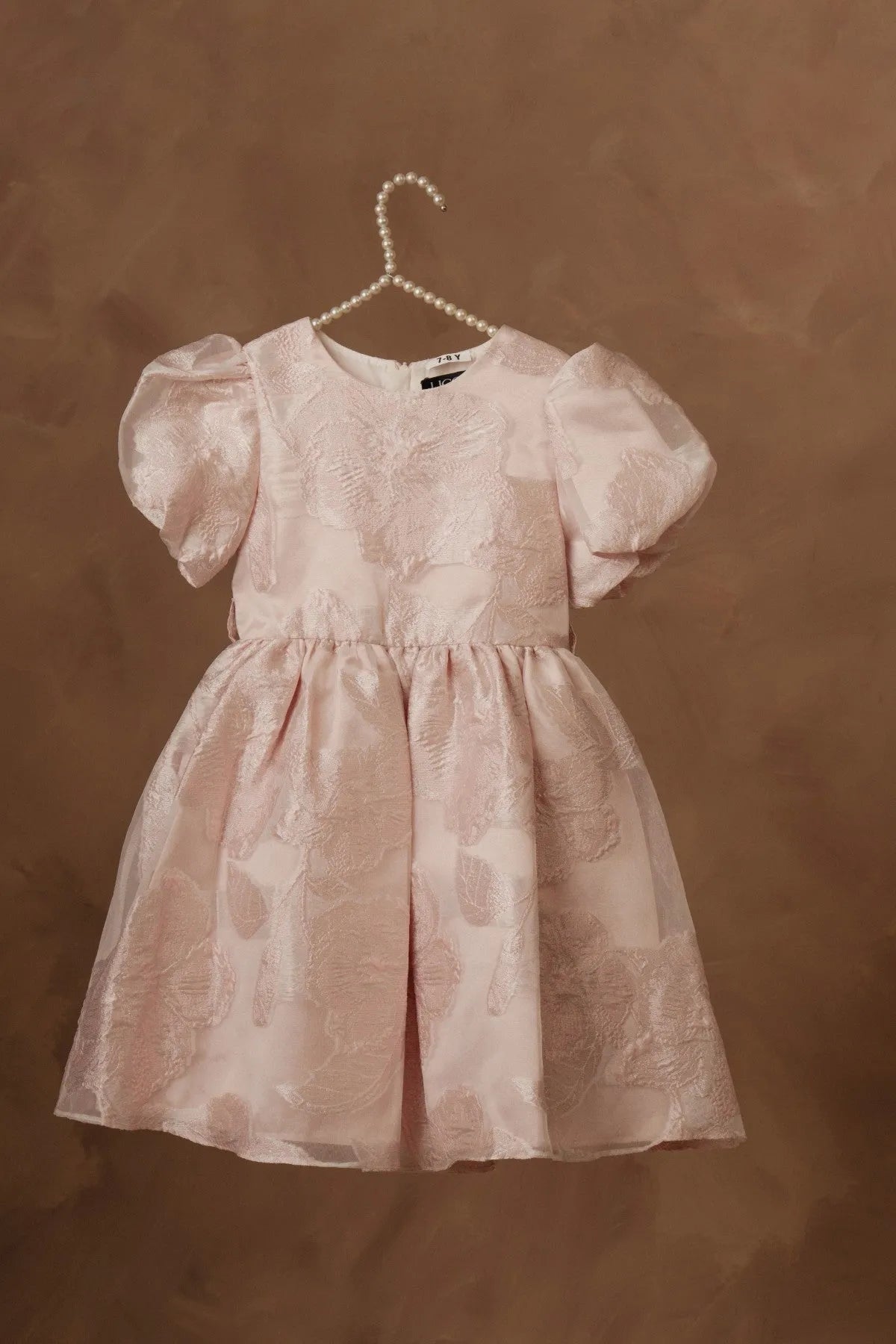 Light pink girls dress with puff sleeves, round neck, and pleated skater skirt