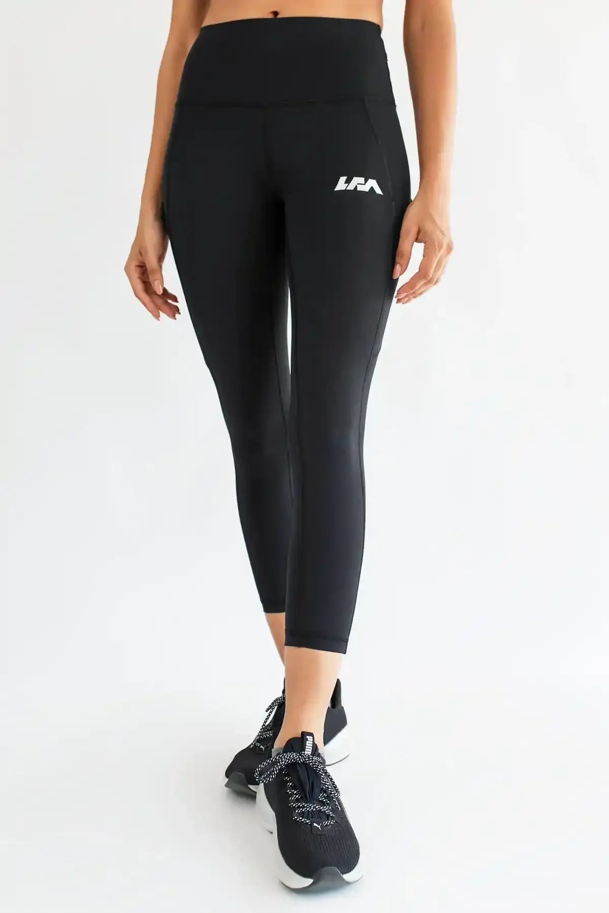 Black cropped leggings with white logo on thigh and slim tapered fit