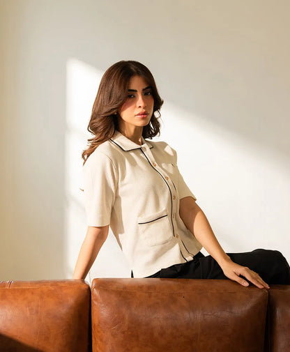Ivory fitted button-up top with stand collar, chest pocket, and short sleeves.