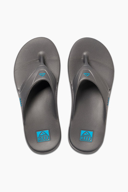 Pair of Reef grey flip-flops, open toe thong style with blue logo labels