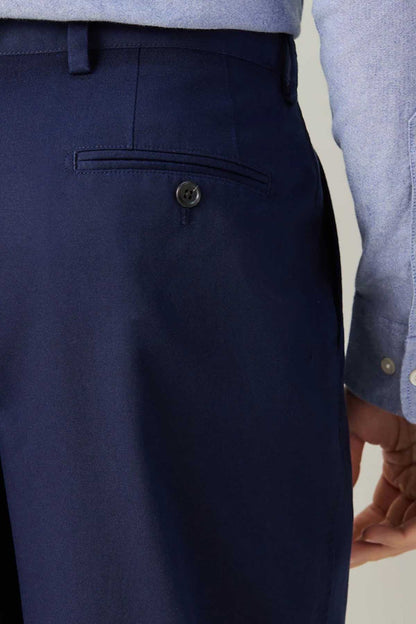 Navy suit trousers, front pocket and button detail close-up