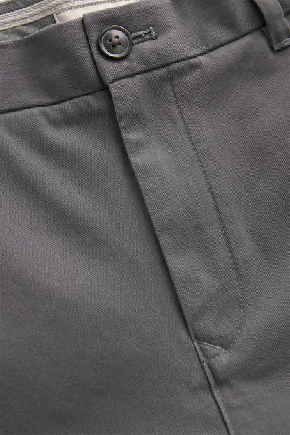 Dark grey trouser fabric close-up with front button and stitched seams