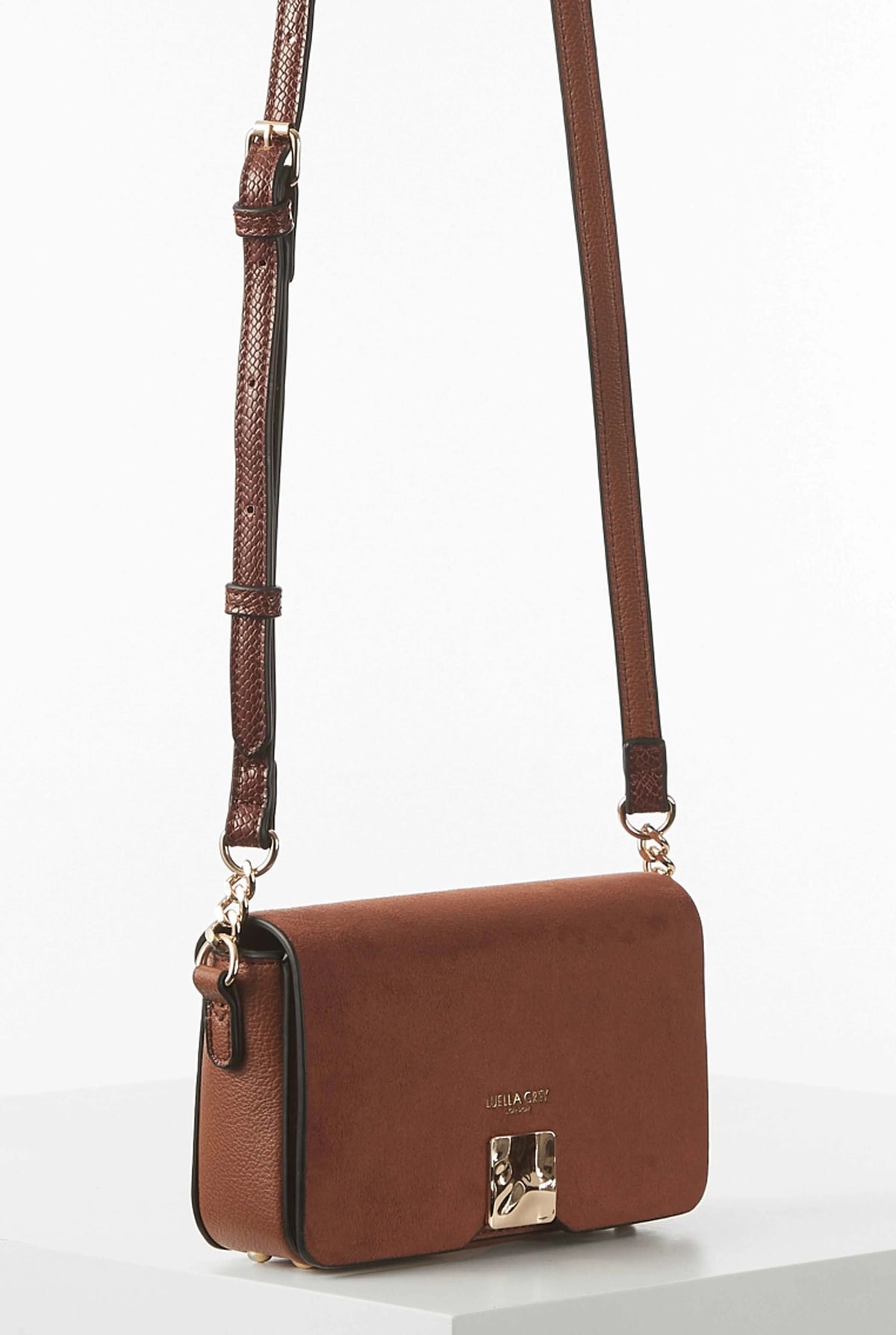Brown flap crossbody bag with front clasp and long adjustable strap