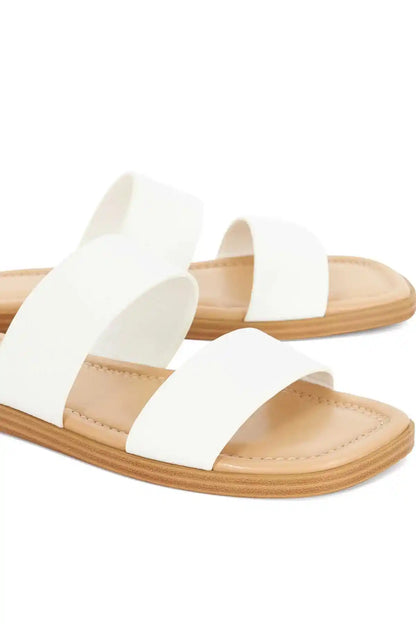 Dune London white slip-on sandals with two straps over footbed and tan outsole