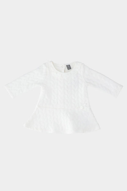 Cream baby dress with textured pattern, long sleeves and flared peplum hem