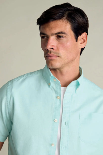 Men's short-sleeve button-up shirt in light aqua green, collar and chest close-up