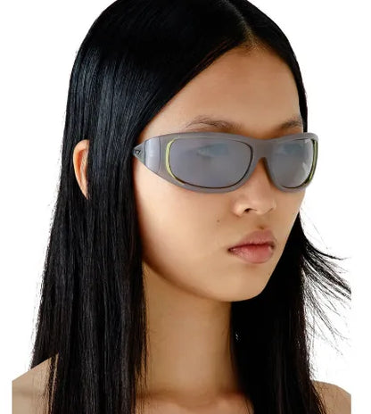 Sunglasses on model: gray lenses with light taupe frame and green temple accents