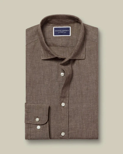 Folded brown button-up shirt with spread collar and white buttons