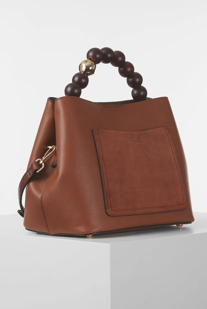 Brown leather handbag with beaded top handle and front square patch pocket.