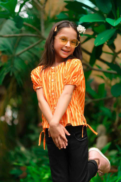 Kids orange striped shirt with tied sleeve details and black pants, front close-up