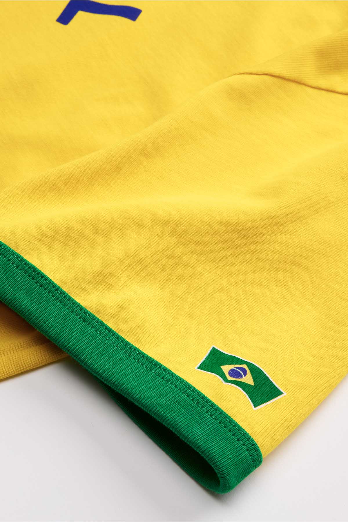 Yellow T-shirt sleeve cuff with green trim and Brazil flag patch