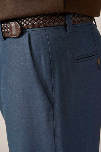 Navy jeans close-up with braided belt, pleated front, and right pocket