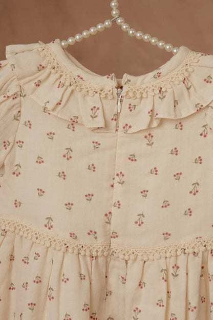 Cream floral baby dress detail: ruffled neckline and button placket with trim