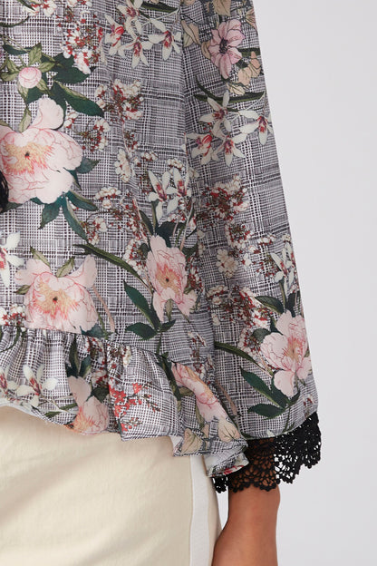 Grey floral blouse sleeve with lace cuff trim and ruffled hem