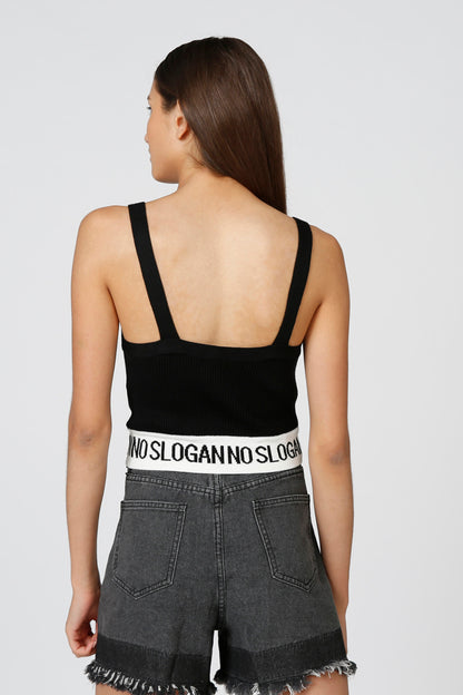 Splash back view: black camisole with crisscross straps and gray frayed denim shorts