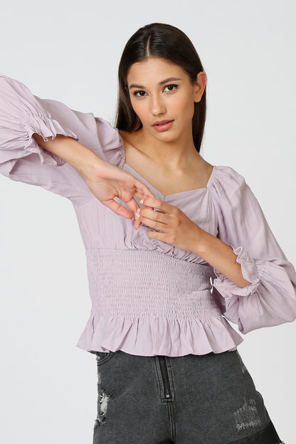 Lavender smocked peplum blouse with square neckline and ruffled cuffs
