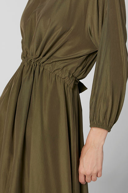 Olive green dress close-up: elastic waist gather and long puff sleeves