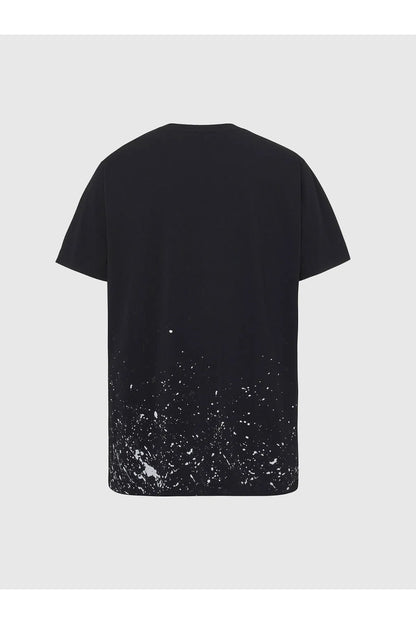 Black T-shirt with white paint speckle pattern on lower back