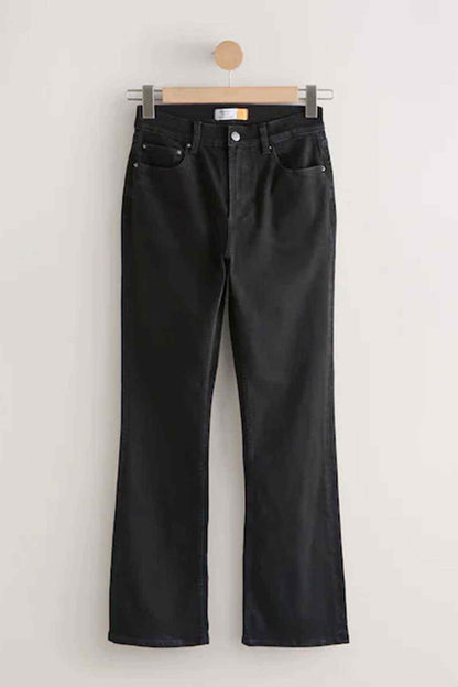 Black wide-leg jeans hanging on a wooden hanger