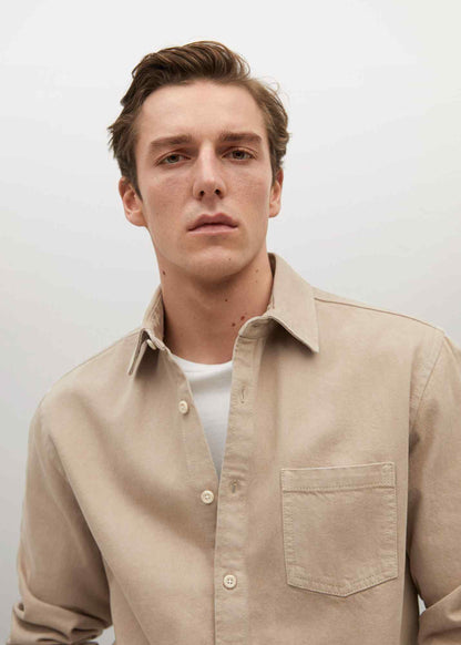 Beige button-up shirt with point collar, button front, and chest pocket detail.