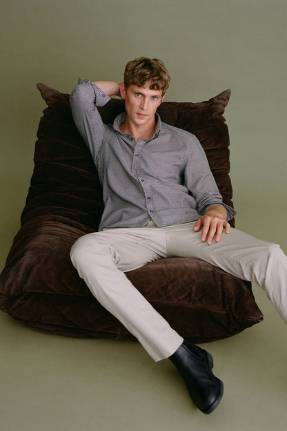 Beige chino trousers on model, straight leg with belt loops and front closure