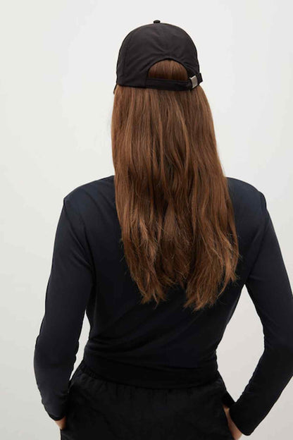 Back view of black long-sleeve top, elastic-waist shorts, and baseball cap