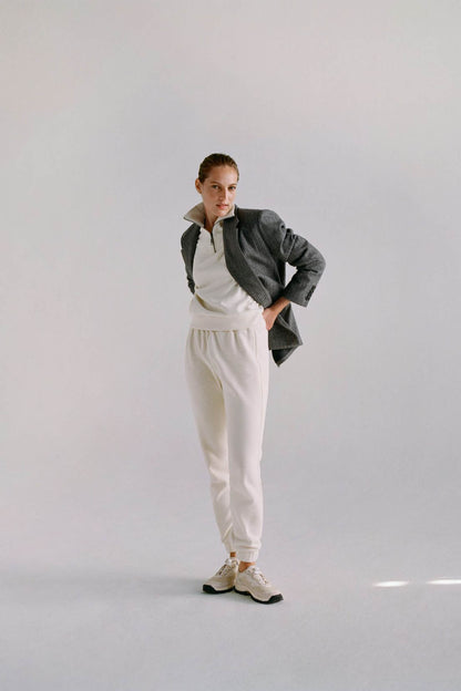 White jogger pants with dark gray zip-up jacket, full body