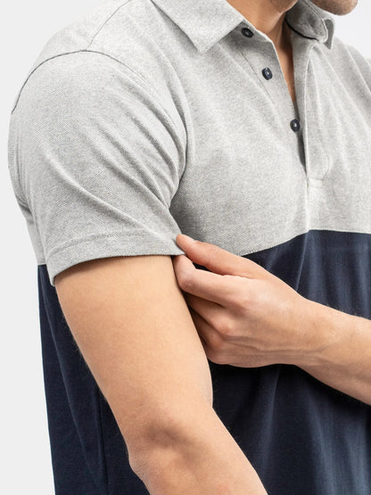 Men's polo close-up: heather gray sleeve, navy lower panel, buttoned placket