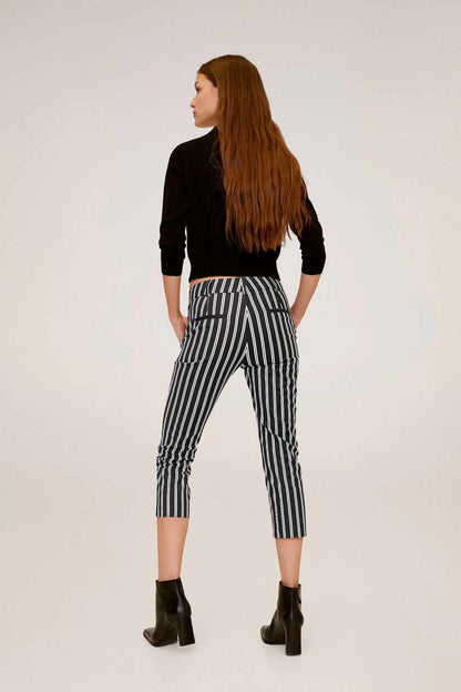 Black cropped knit sweater with vertical stripe capri pants, back view