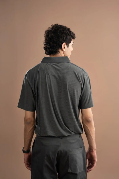 Back view of men's grey short-sleeve button-up shirt with collar; dark trousers