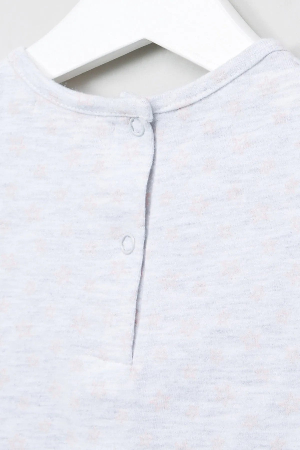 Lightweight baby top close-up: buttoned henley placket at crew neckline
