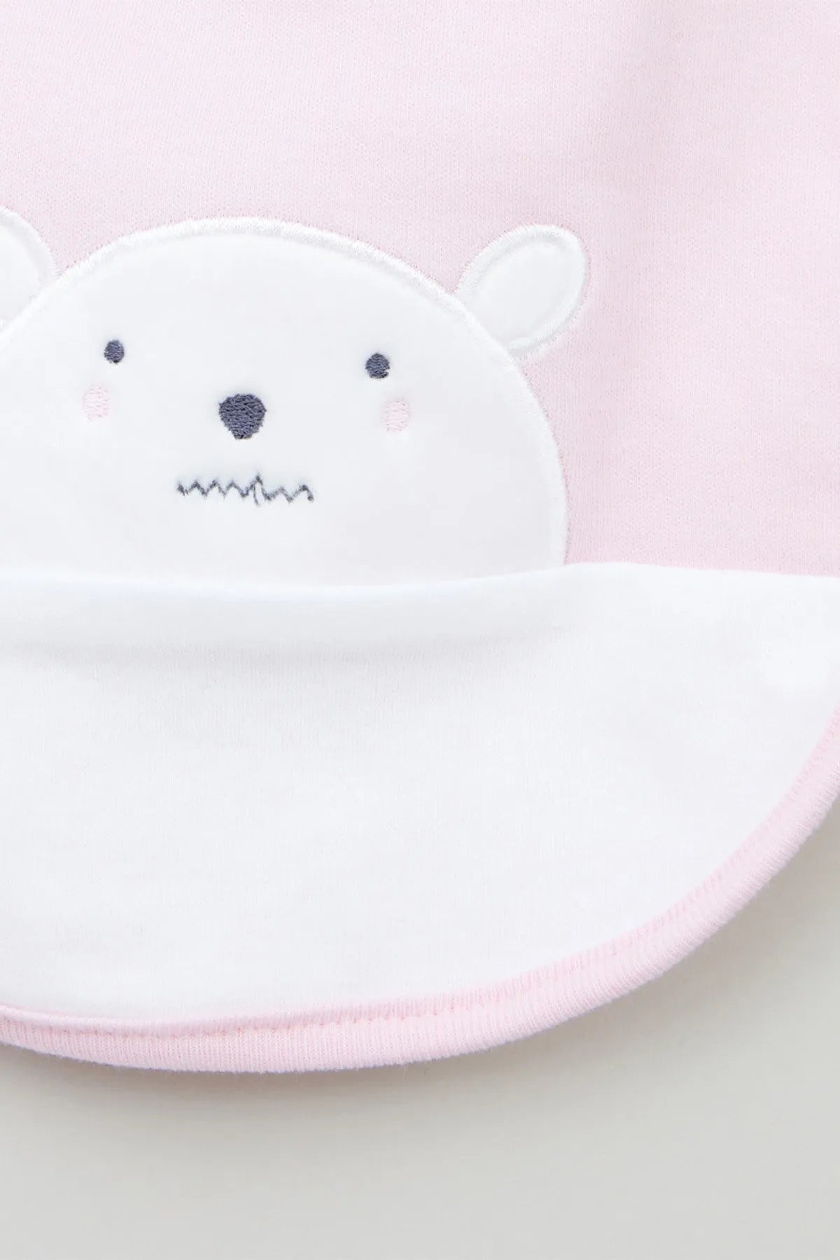 Pink and white baby bib with white bear face applique detail