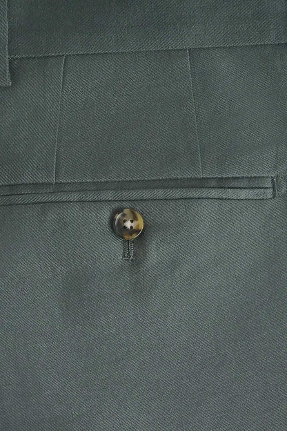 Green suit trouser button on textured fabric