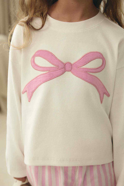 White sweater with embroidered pink bow on chest