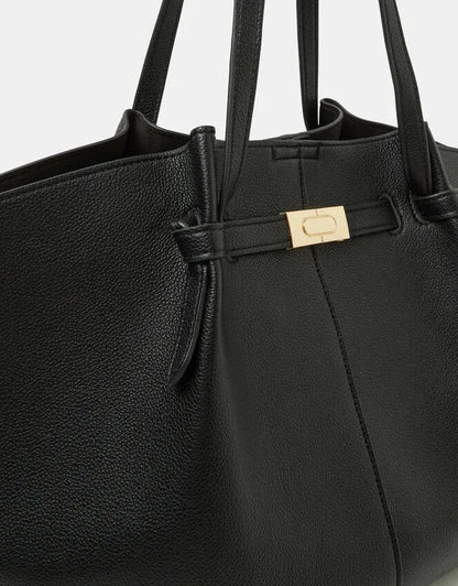 Black tote bag with gold buckle front strap and zip pocket detail