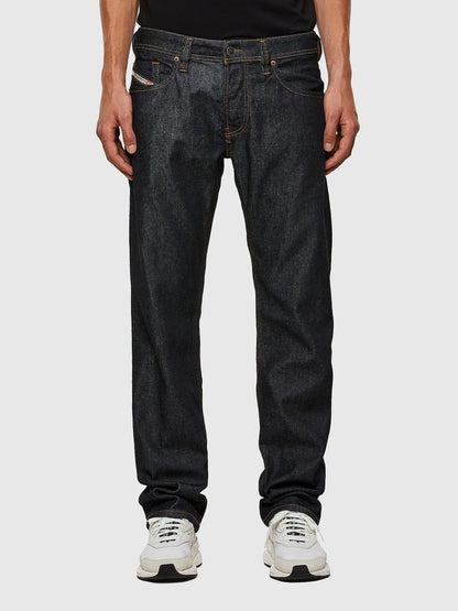 Dark indigo denim jeans with orange-stitched seams and back patch pockets
