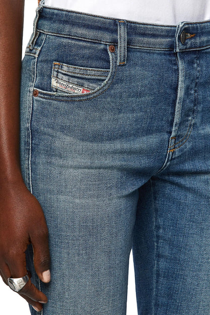 Light blue denim jeans showing front pocket with stitched logo patch and coin pocket