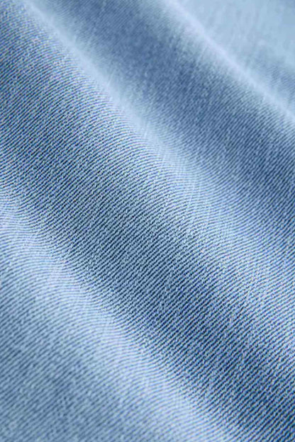 Light blue denim fabric close-up showing fine woven texture