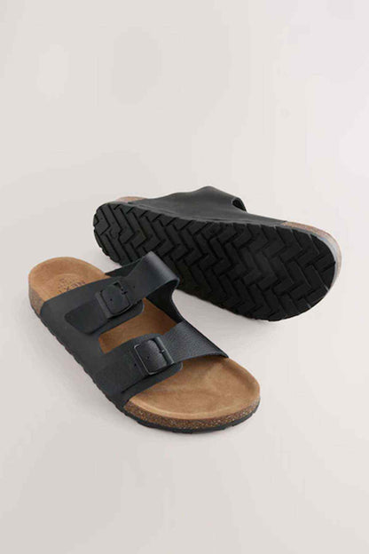 Black slide sandals with cork footbed and textured tread outsole