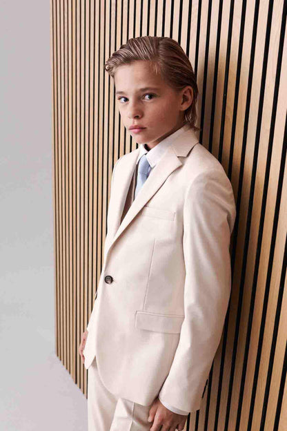 Cream suit jacket with chest pocket and notch lapels, paired with blue tie