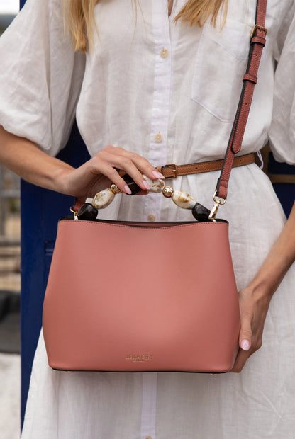 Pink leather-look handbag with beaded handles and front logo patch