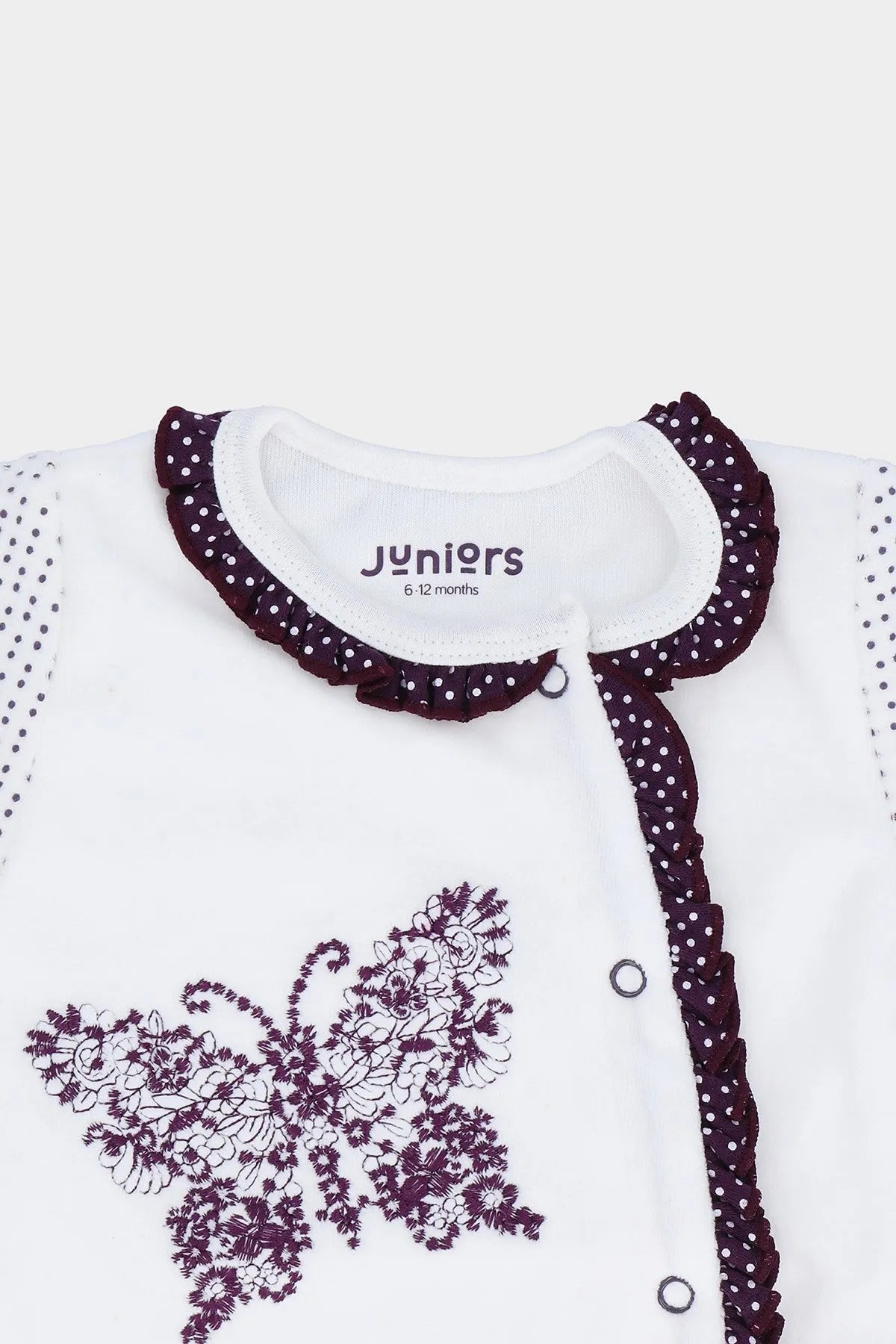 White baby onesie with purple floral patch, dark trim and snap button placket