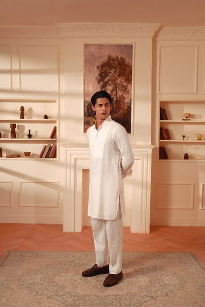 Men's white kurta and pants set with long sleeves and buttoned collar