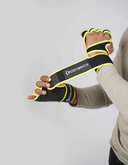 Black Bodybrics fingerless weightlifting glove with yellow trim and wrist strap detail.
