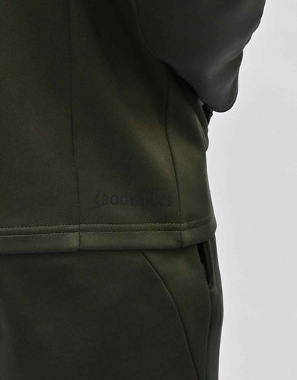 Bodybrics olive zip-up jacket with matching pants; logo text on hem area close-up