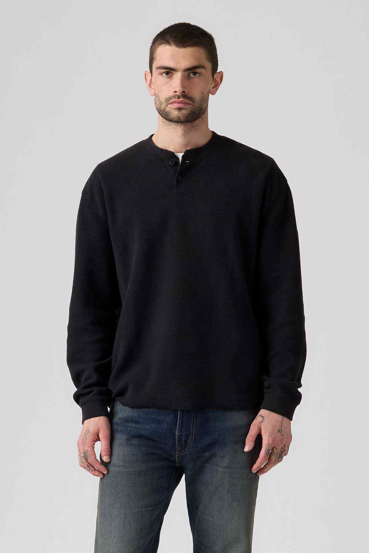 Black long-sleeve henley with three-button placket, casual jeans